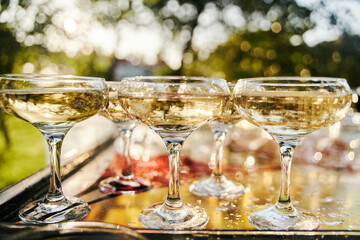 Table set for an event party or wedding reception. Banquet table design. Festive glasses with champagne and white wine.