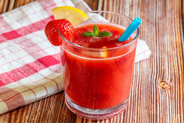 Glass of fresh strawberry smoothie on wooden background