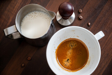 Preparation of cappuccino with espresso and milk in cup 