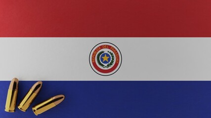 Three 9mm bullets in the bottom left corner on top of the national flag of Paraguay