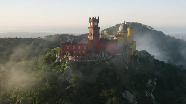 The colorful ancient castle with beautiful views over the Sintra region. Drone footage of The Palacio da Pena at the top of a steep hill. Europe, Portugal, Pena Palace. High quality 4k footage