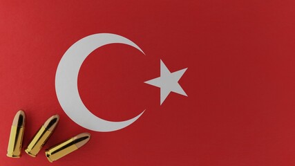 Three 9mm bullets in the bottom left corner on top of the national flag of Turkey