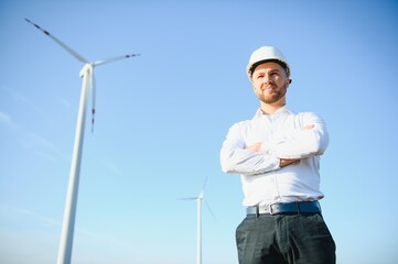 Engineer in wheat field checking on turbine production