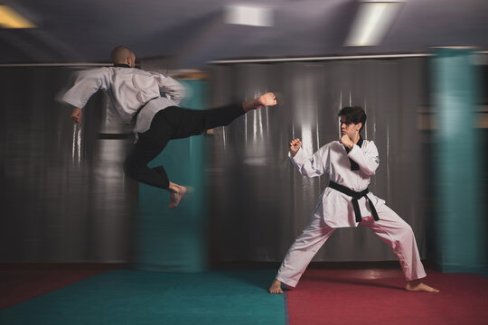 two masters of
taekwondo fighting in a match.
