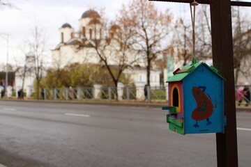 bird feeder on city street and view on the old chuch