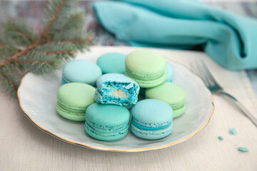 Winter festive macaroons on a plate, Pistachio and coconut flavor French macaron cookies on a plate