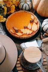 Autumn baking background with pumpkin pie pumpkin yellow autumn leaves on wooden background
