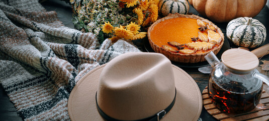 Autumn baking background with pumpkin pie pumpkin yellow autumn leaves on wooden background