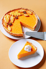 Delicious Fresh Homemade Thanksgiving Pumpkin Pie with a sliced wedge ready to be eaten