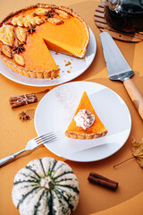 Delicious Fresh Homemade Thanksgiving Pumpkin Pie with a sliced wedge ready to be eaten