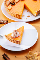 Delicious Fresh Homemade Thanksgiving Pumpkin Pie with a sliced wedge ready to be eaten