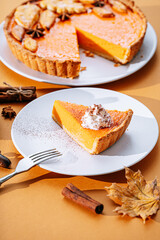 Delicious Fresh Homemade Thanksgiving Pumpkin Pie with a sliced wedge ready to be eaten