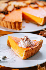 Delicious Fresh Homemade Thanksgiving Pumpkin Pie with a sliced wedge ready to be eaten