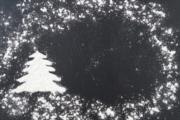 Top view of pine tree shape and snow around made from white flour, copy space, place for inscription. Christmas concept