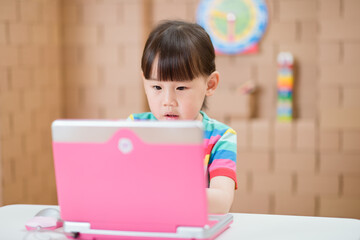 young girl using laptop for online learning during lockdown time