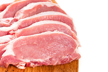 chopped into pieces raw pork on a wooden cutting board on a white background.
