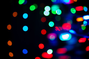 Black elegant background with multicolored bokeh. Decorative defocusing effect. Random composition