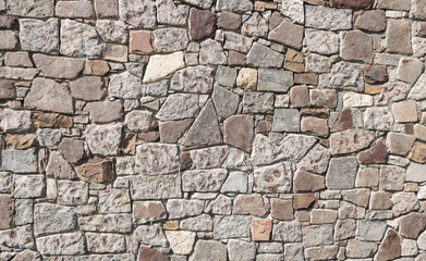 Multi-colored stone wall, artistic grey material background. Abstract detail seamless wall. Exterior ancient loft style texture concept. Abstract material background, rough and weathered surface.