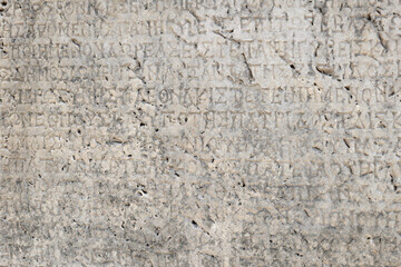 Ancient Greek inscriptions on stone in archeological ruin in ancient Greece site - design,...