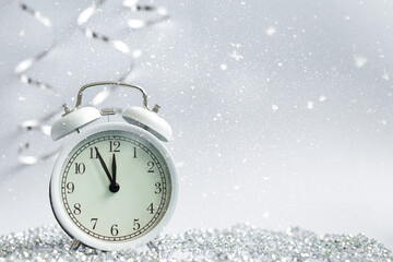Fototapeta na wymiar New Year clock with snow. Festive bright Christmas background. Five minutes to midnight
