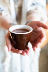Cacao ceremony. Female hand holding a cup of pure shamanistic ceremonial cacao drink.