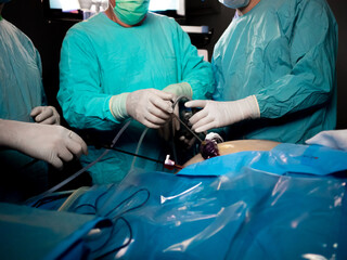Selective focus on the hands of surgeons wearing sterile gloves during a surgical operation....