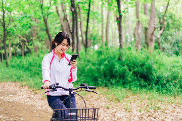 自転車に乗りながらスマホを使う女性