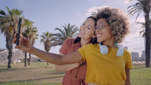 Gay couple of girlfriends take a picture with their cell phones. Concept of summer, vacation, having fun, traveling,