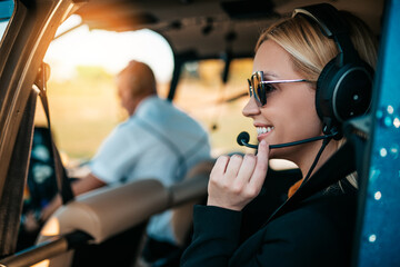 Attractive middle age business woman using private air transport chopper or helicopter to travel to...