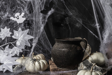Halloween composition with witch's pot, pumpkins, bat, ghost, spider, and cobwebs