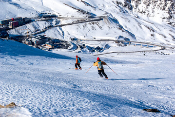 Two person skiing downhill out of track with Pas de la Casa at the bottom