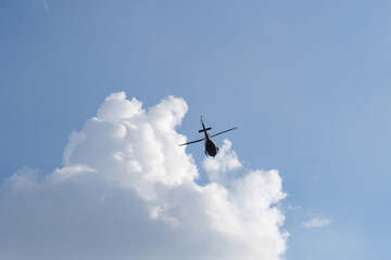 Fototapeta na wymiar On the azure sky, a helicopter flies.
