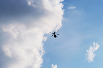 On the azure sky, a helicopter flies.