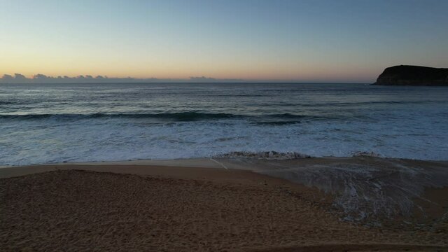 Sunrise seascape with clear skies and waves at Copacabana on the Central Coast, NSW, Australia.