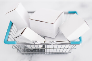 shopping and add to cart concept, parcels of different shapes piled up inside of shopping basket on light marble background