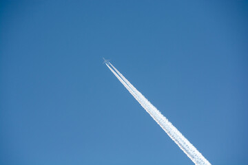 冬の晴れた青空を飛ぶ飛行機