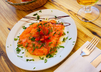 Delicious fresh salmon carpaccio dressed with tomatoes and balsamic sauce