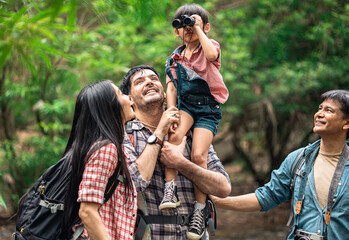 Fototapeta premium A group of young Asians are planning and looking at maps for camping in the forest.Asian and caucasian are backpackers.Tourism, adventure and summer vacation concept