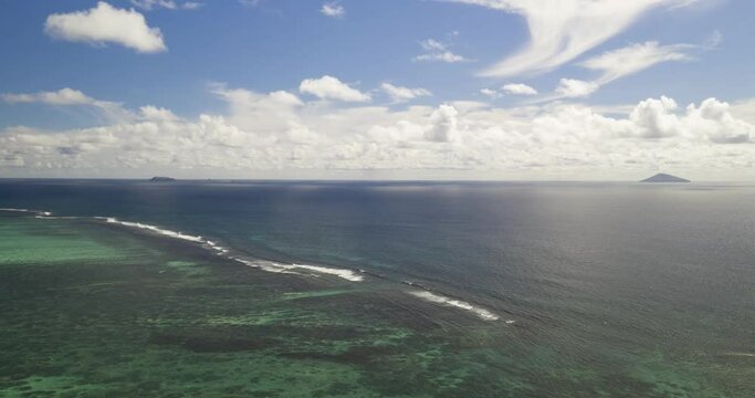 Aerial: Reversing over tropical lagoon hyperlapse on sunny day with islets in background Mauritius