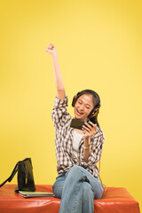 excited girl with headphones using a smartphone raise her hand