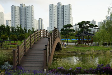 김포호수공원에는 고층아파트와 산책하는 사람들과 휴식하는 사람들이 있습니다.