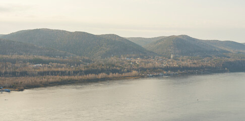 Bank of the Yenisei River near  city of Krasnoyarsk. Autumn season. Mountainous landscape. Water surface, Siberian forest.