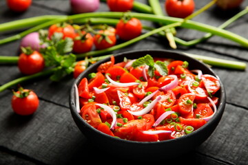 Bowl of fresh tomato salad with herbs.