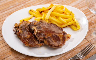 Grilled barbecue pork meat with baked potato and dip on a plate