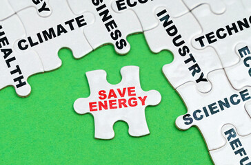 On a green background, white puzzles with text, a puzzle with the inscription - Save Energy