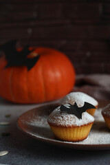 powdered muffins with pumpkin, pumpkin seeds and black bat