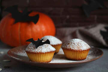 powdered muffins with pumpkin, pumpkin seeds and black bat