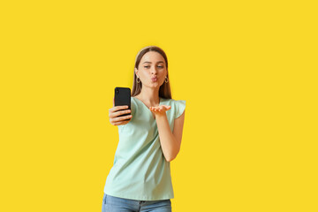 Naklejka premium Pretty young woman taking selfie on color background