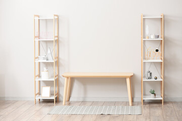 Wooden TV stand and shelving units near light wall