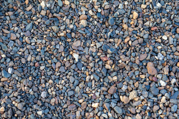 Crushed stone on the seashore. Selective focus on object. The stones were laid on the ground in the garden as a background. Background blur. Pebble stones background.